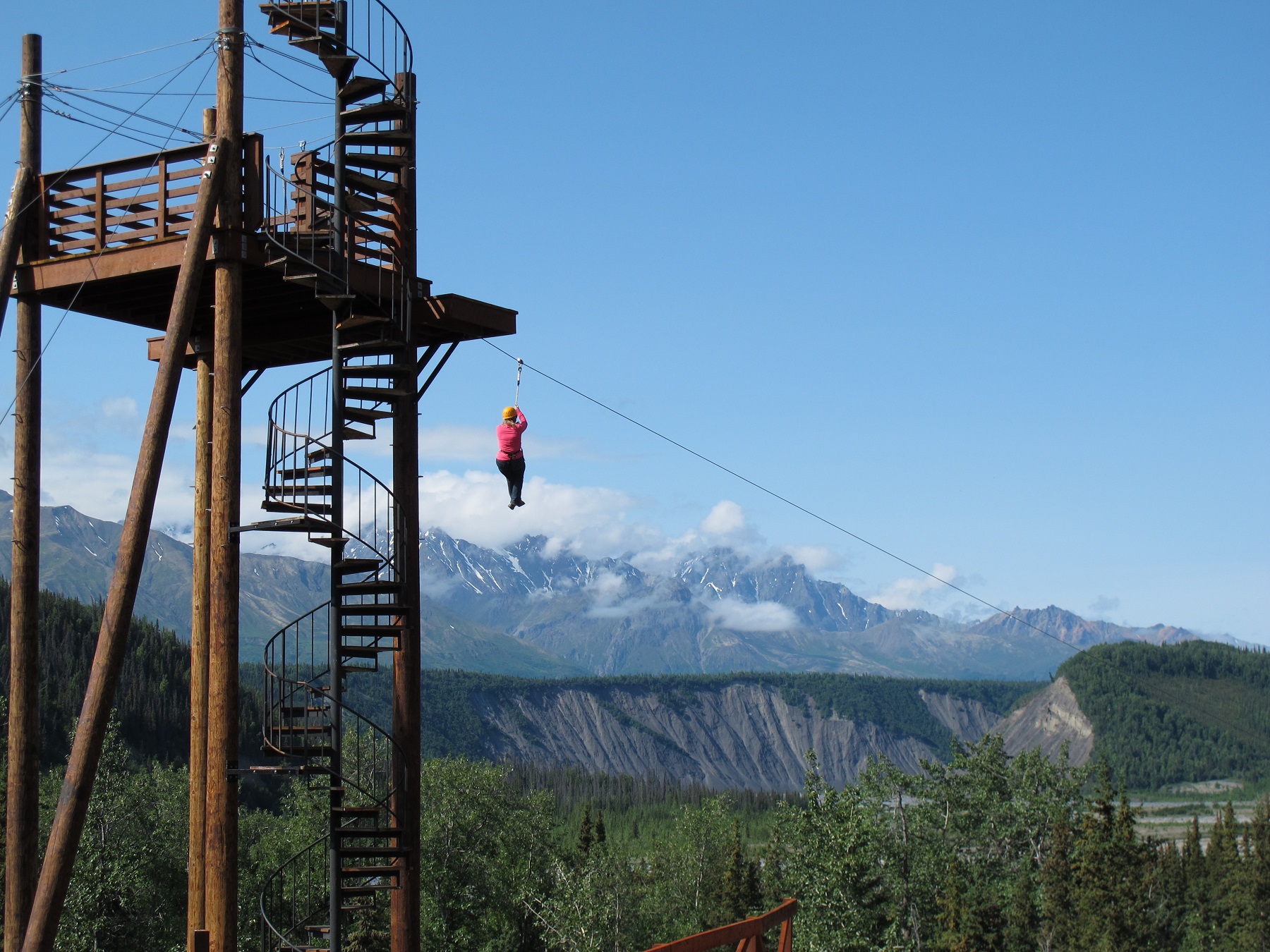 person launching from zipline over mountains