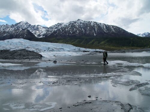 person walking on glacier