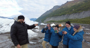 people cheers their drink on a glacier