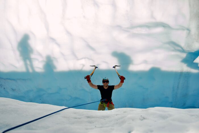 Solo ice climber in glacier crevasse