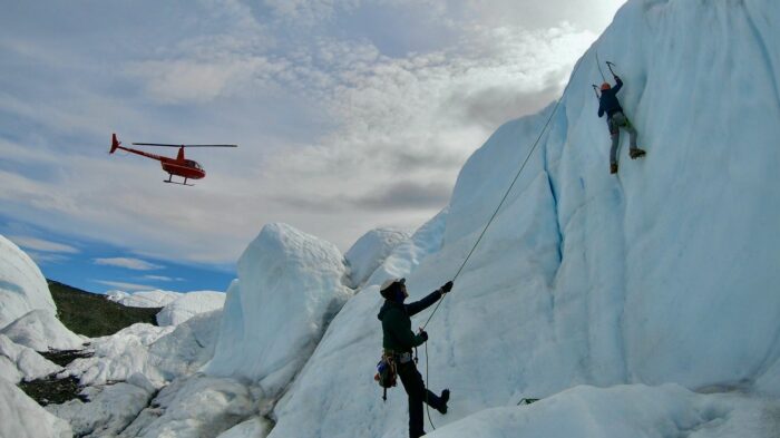 helicopter over glacier and ice climbers