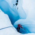 human in red jacket in blue ice