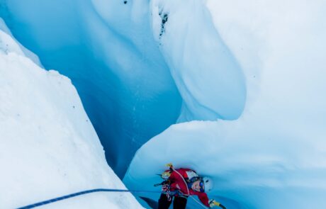 human in red jacket in blue ice