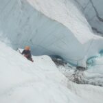 ice climber on glacier above water
