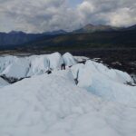 person on glacier with mountains