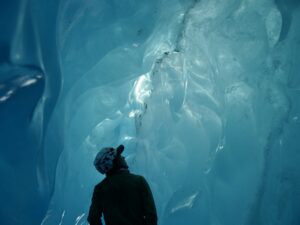 person hiking into glacier cave