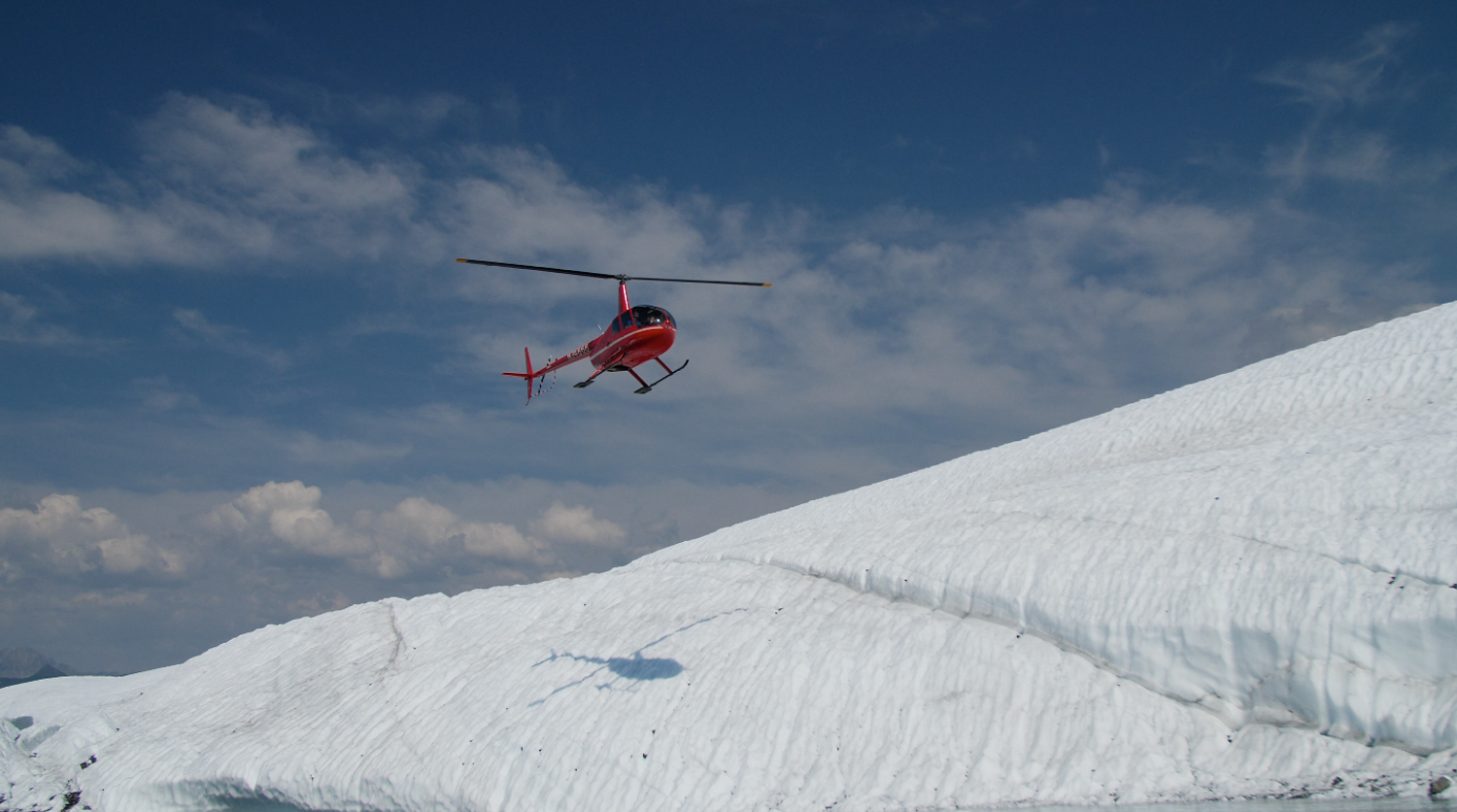 helicopter landing on white ice on glacier