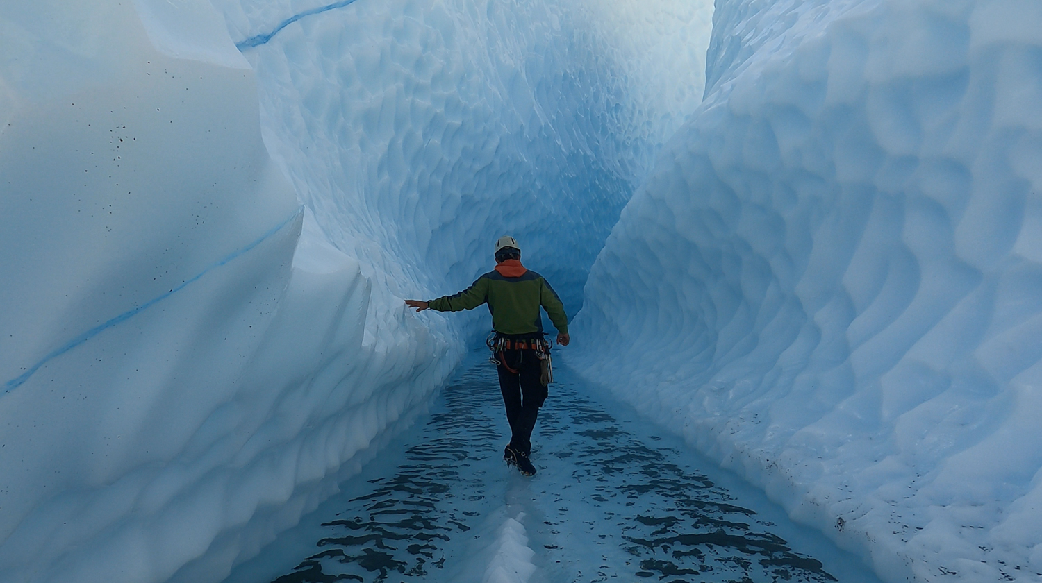 person walking in blue ice canyon