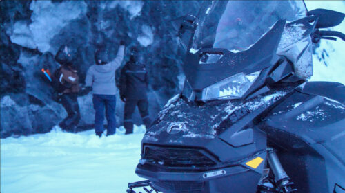 snowmobile in front of Alaskan glacier in winter