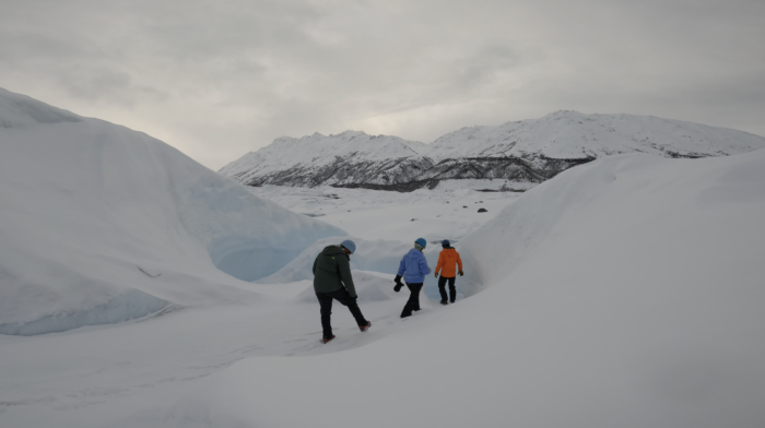 people walking into an Alaska glacier canyon