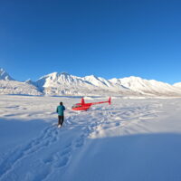 Helicopter on snow near mountains in Alaska