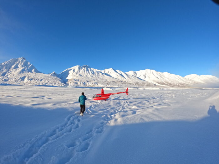 Helicopter on snow near mountains in Alaska